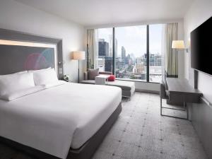 a hotel room with a large bed and a large window at Novotel Bangkok Platinum Pratunam in Bangkok