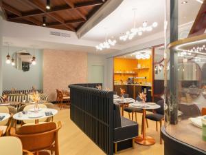 a restaurant with tables and chairs in a room at Grand Hotel des Brotteaux Lyon Ctre - Handwritten Collection in Lyon +57 photos