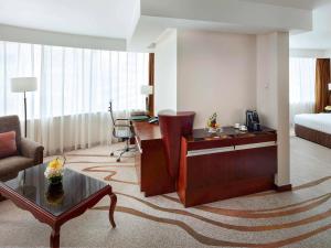 ein Wohnzimmer mit einem Sofa und einem Tisch in einem Hotelzimmer in der Unterkunft Pullman Shanghai Central - In XinTianDi & Yu Garden Area in Shanghai