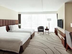 ein Hotelzimmer mit zwei Betten und einem Fernseher in der Unterkunft Pullman Shanghai Central - In XinTianDi & Yu Garden Area in Shanghai