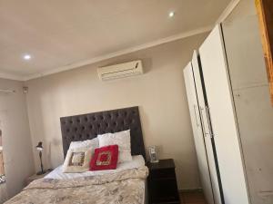 een slaapkamer met een bed met twee kussens erop bij Jakaranda house in Pretoria