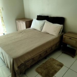 1 dormitorio con 1 cama con 2 almohadas y mesa en Sobrado vista mar Piçarras, en Piçarras