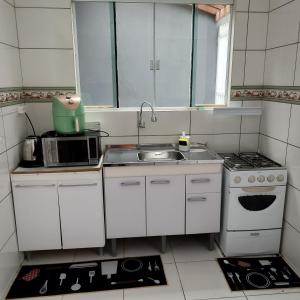Una pequeña cocina con fregadero y estufa. en Sobrado vista mar Piçarras, en Piçarras