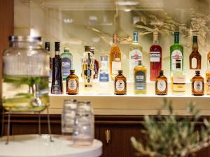 a shelf filled with lots of bottles of alcohol at Hotel Faubourg Galant Paris - Handwritten Collection in Paris