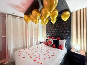 a bedroom with gold balloons and a bed with red hearts at Jacuzzi Suites in Halifax