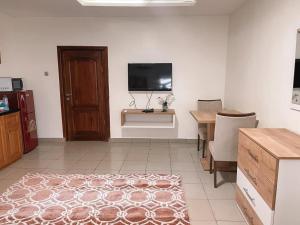 uma sala de estar com uma televisão e uma mesa com uma mesa de sidx em Bosco em Accra