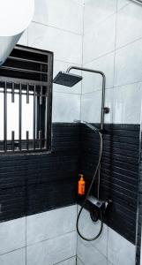 a shower with a orange candle on a wall at Luigi Homes in Kampala