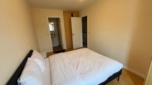 a bedroom with a white bed in a room at Wilmer House on Drum Road in Eastleigh +7 photos