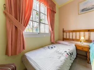 Un dormitorio pequeño con una cama y una ventana. en Luxury apartment with garden views, en El Médano 14 fotos más