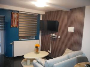Una sala de estar con un sofá, una mesa y un televisor. en VancyLove Home, en Mons