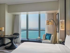 a hotel room with a bed and a large window at Sofitel Abu Dhabi Corniche in Abu Dhabi