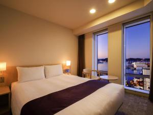 a hotel room with a bed and a large window at Mercure Yokosuka in Yokosuka +88 photos