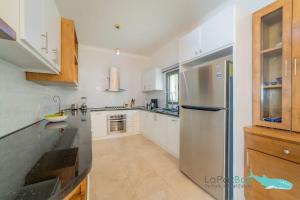 a kitchen with white cabinets and a stainless steel refrigerator at Brand New Townhome with Private Rooftop in La Paz