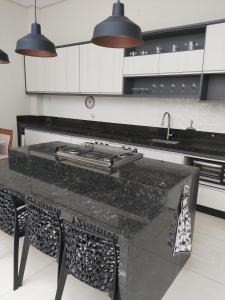 a kitchen with a black counter top with a sink at Home of happiness in Monte Sião