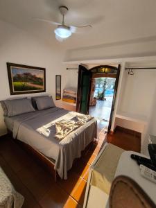 Un dormitorio con una cama con ventilador de techo. en Pousada Na Praia Ubatuba, en Ubatuba