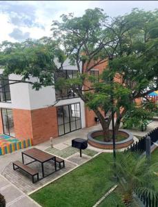 a park with a bench and a picnic table in front of a building at Apartamento completo con piscina in Cartago