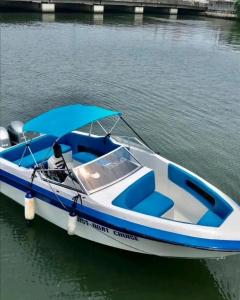 a blue and white boat with an umbrella on the water at Richesther cruise world in Lagos