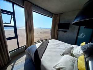 a bedroom with a bed with a view of the beach at Berry's Farm in Vosburg