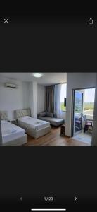 una habitación de hotel con dos camas y un sofá en AMANTIUS APARTMENTS, en Borsh 22 fotos más