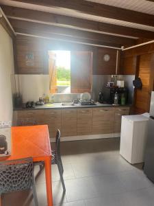 a kitchen with wooden cabinets and a table and a window at Le gîte de Chris in Sainte-Anne