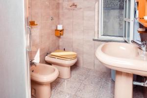 a bathroom with a toilet and a sink at Attico Bouganville in Porto Alabe +29 photos