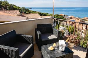 a balcony with two chairs and a table with a view of the ocean at Attico Bouganville in Porto Alabe