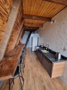 a kitchen with a long counter and a wooden ceiling at Cabana da Praia in Rio Grande