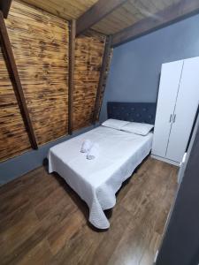 a small bedroom with a bed in a room with wooden floors at Cabana da Praia in Rio Grande