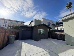 a backyard with a black garage and a fence at New Luxury 1BR ADU Near Downtown & Tech Hubs in San Jose