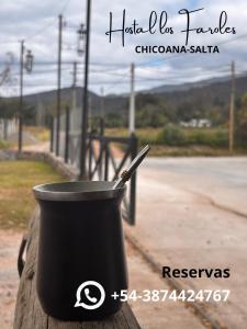 une tasse noire avec un stylo dedans sur une table dans l'établissement Hostal Los Faroles Chicoana, à Chicoana