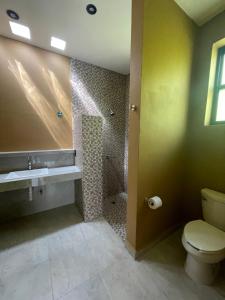 een badkamer met een toilet en een douche bij Casa Colibrí in Zipolite +7 foto's