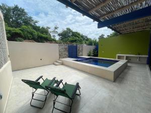 a patio with two chairs and a swimming pool at Casa Colibrí in Zipolite