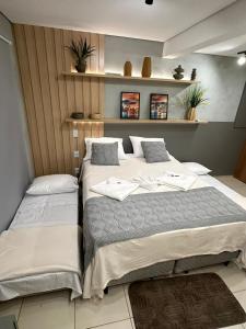 two beds sitting next to each other in a room at Diamante de Ribeirão Conforto e ótima localização! in Ribeirão Preto