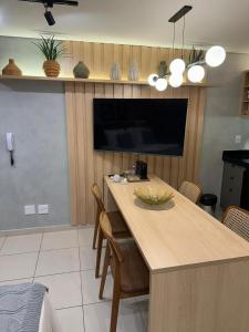 a kitchen with a table with chairs and a tv at Diamante de Ribeirão Conforto e ótima localização! in Ribeirão Preto