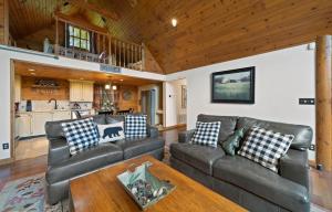 a living room with leather couches and a wooden ceiling at Little Heaven in Banner Elk