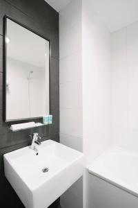 un bagno con un lavandino bianco e uno specchio di Value Hotel Balestier a Singapore Altre 14 foto