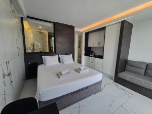 a bedroom with a large white bed and a couch at Leopard Rock E4 Puerto Rico Views in Puerto Rico de Gran Canaria +13 photos