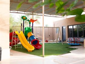 a playground with a slide and a slideintend at استراحة روضة الوادي - Rawdat Al Wadi House in Nizwa