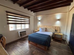 a bedroom with a bed with a blue blanket and a window at Hotel Paris in Tijuana +19 photos
