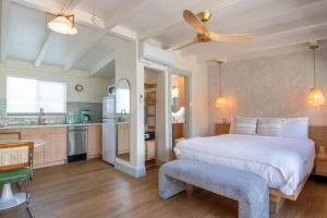 a bedroom with a large white bed and a kitchen at The Boardwalk Hotel in San Diego