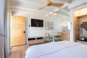 a bedroom with a bed and a flat screen tv at The Boardwalk Hotel in San Diego