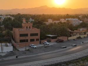 a view of a city with cars parked in a parking lot at استراحة روضة الوادي - Rawdat Al Wadi House in Nizwa