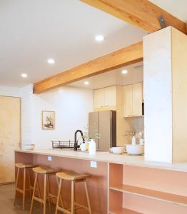 una cucina con soffitti in legno e bancone con sgabelli di Sonoran Peach House - 5BR Winter Retreat, Big Yard, Fireplace a Tucson Altre 31 foto