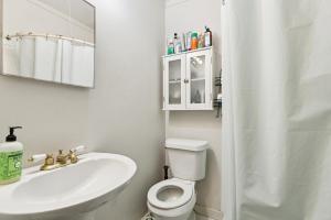 a white bathroom with a toilet and a sink at Nola Swamp Farm in Terrytown +8 photos