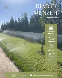 a sign in the grass next to a field at Riad el menzeh in Bouznika