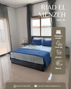 a bedroom with a bed with blue pillows and a sign at Riad el menzeh in Bouznika