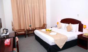 a hotel room with a bed and two chairs at Ibri Oasis Hotel in Ibri
