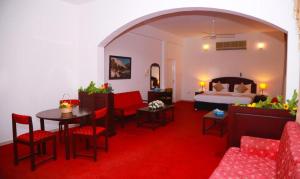 a hotel room with a bed and a table and chairs at Ibri Oasis Hotel in Ibri