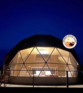 a large glass igloo building with a light inside at RUM BULSE BUBBLE lUXURY CAMP in Disah +10 photos