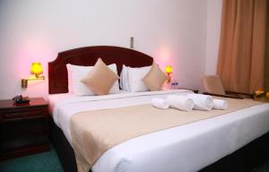 a bedroom with a large bed with towels on it at Ibri Oasis Hotel in Ibri